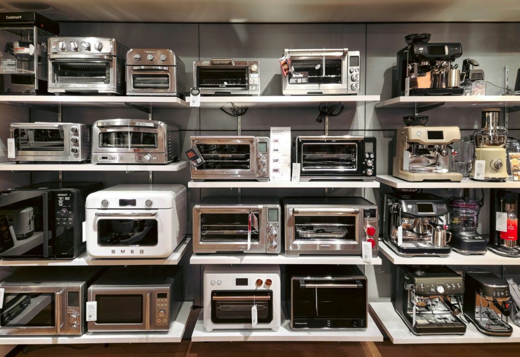 A bunch of microwaves that are on a shelf